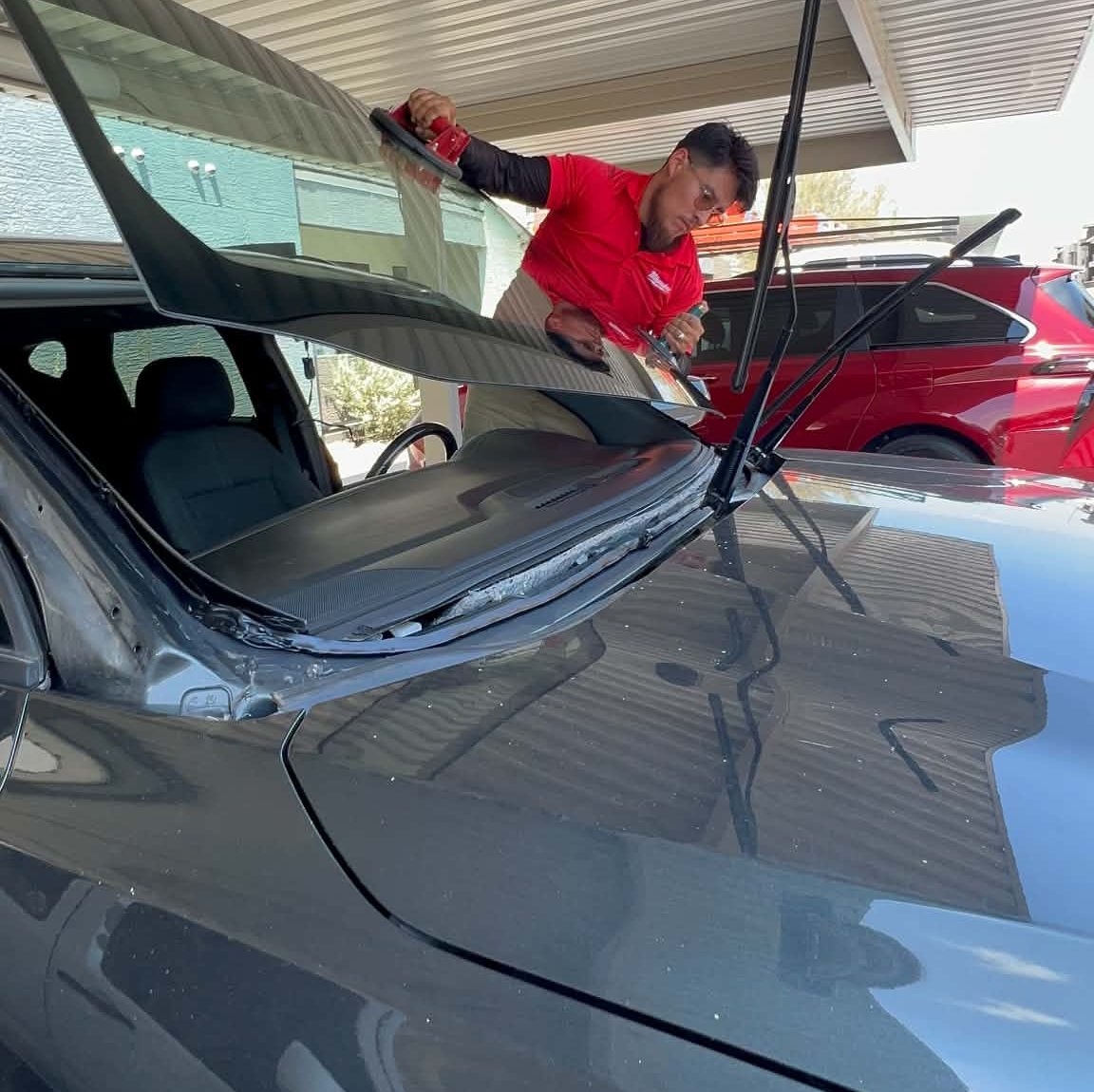 Technician removing a windshield for replacement